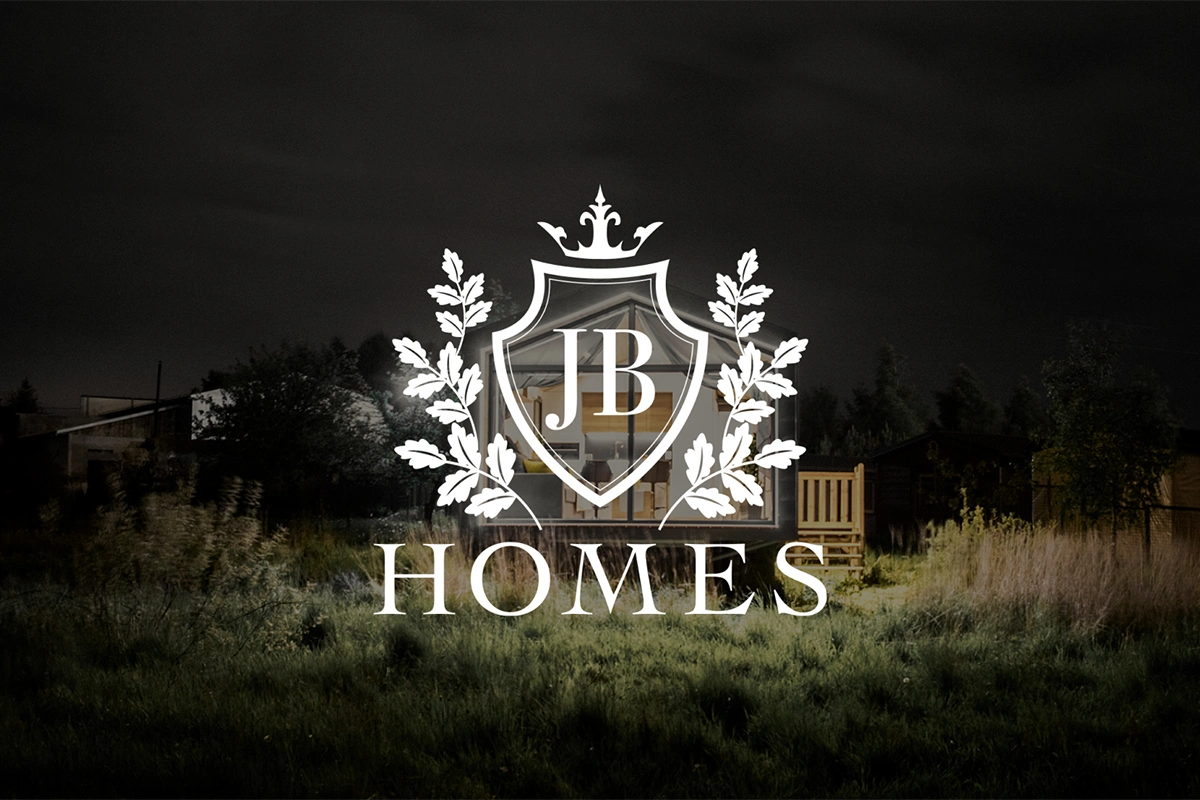 Logo JB Homes przedstawia elegancki herb z inicjałami „JB” otoczonymi liśćmi dębu i koroną, symbolizując prestiż i ekskluzywność. Białe logo kontrastuje z ciemnym, nowoczesnym tłem domu, podkreślając luksusowy charakter marki.