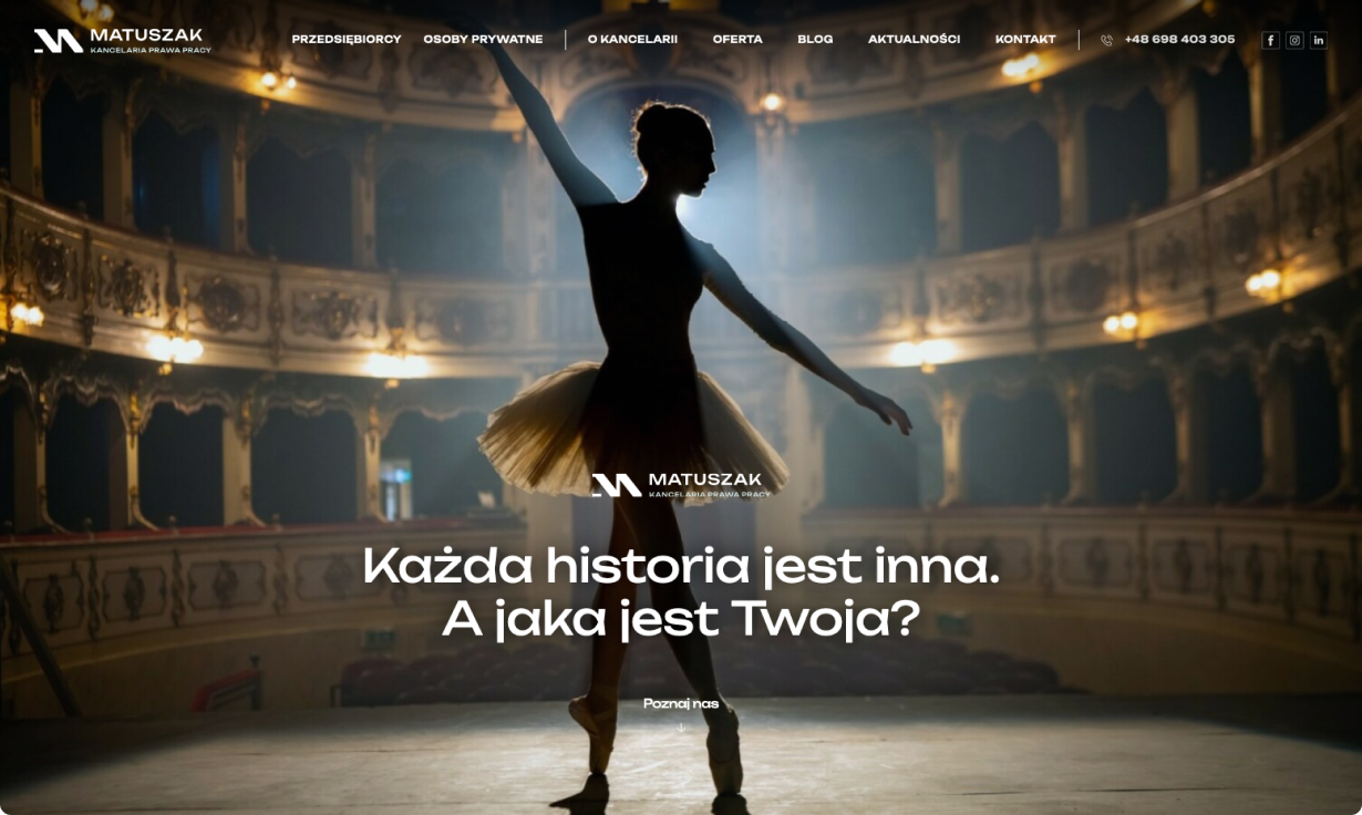 Na zdjęciu widzimy baletnice stojąca na scenie teatru. Osoba jest ubrana w klasyczny strój baletowy: czarny top i jasną spódnicę (tutę). Scena jest oświetlona miękkim światłem
