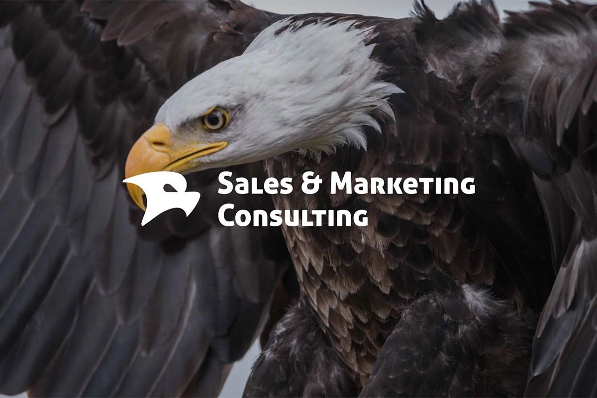 Logo Sales & Marketing Consulting z orłem w tle symbolizuje siłę, strategię i wizję. Dynamiczna czcionka i nowoczesny sygnet podkreślają profesjonalizm.