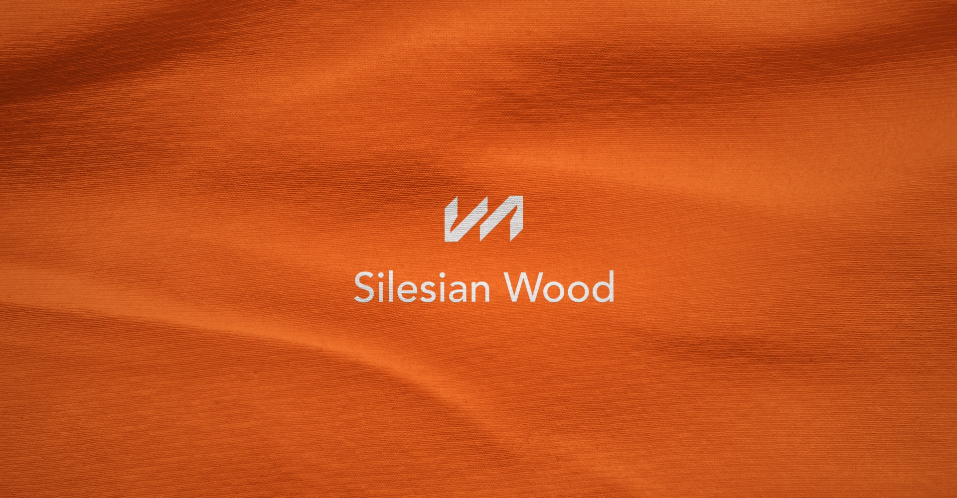 Logotyp silesian-wood na pomarańczowym materiałowym tle